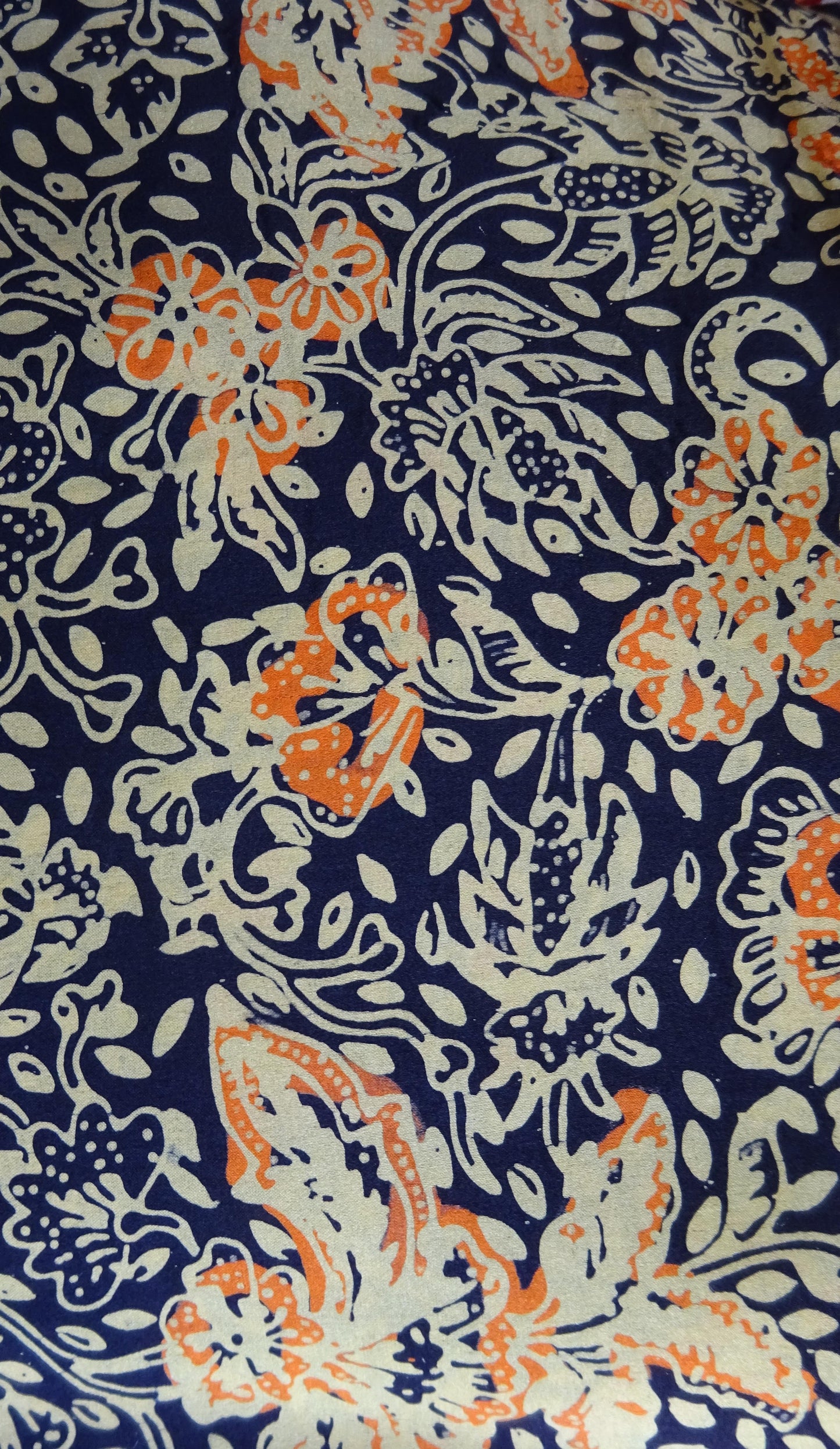 Handgebatikter Seidenkurzschal in Dunkelblau mit Orange und Beige, floral gemustert, doppelt genäht für weichen Fall, 118 x 20 cm.