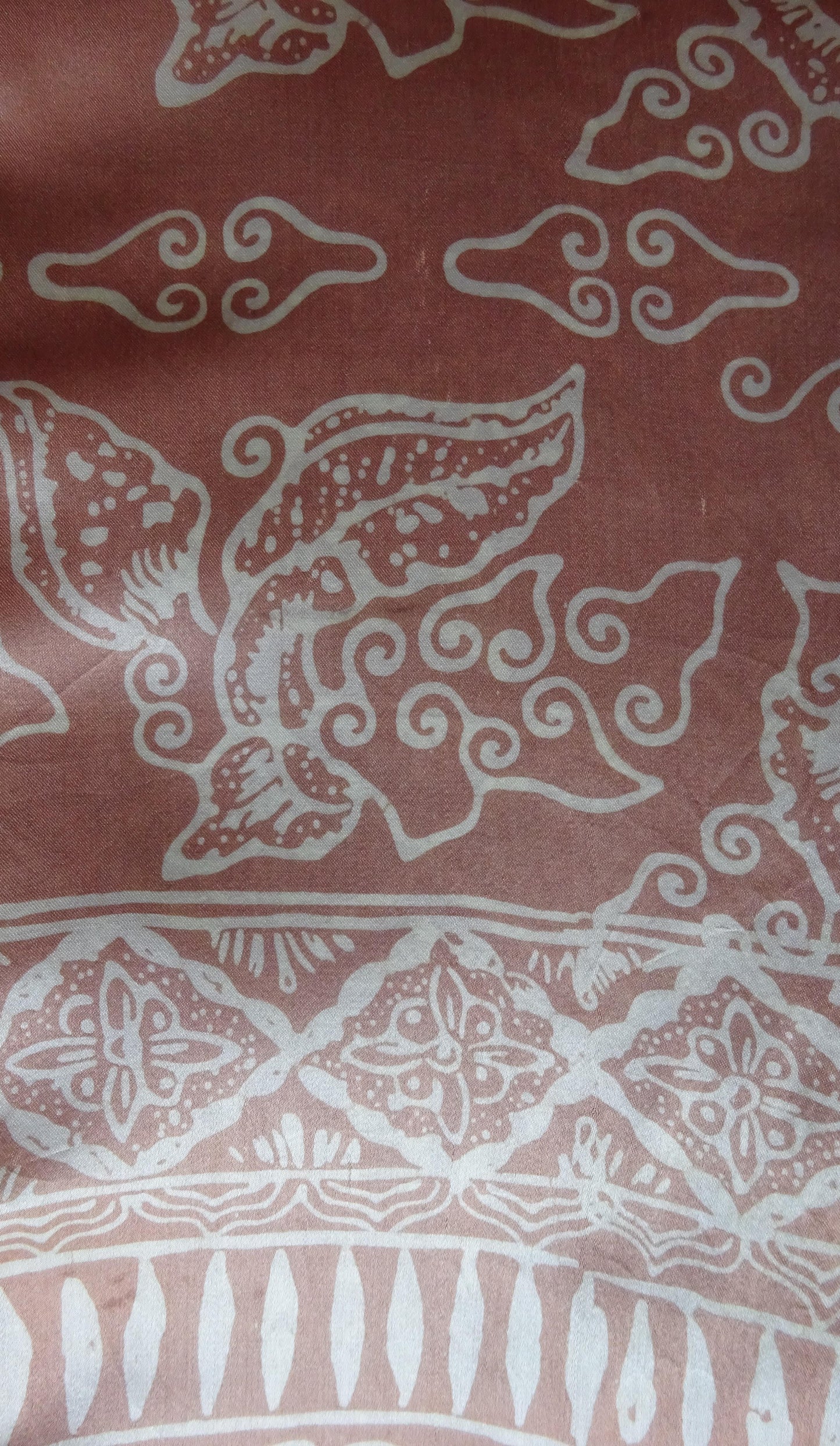 Handgefertigter Seidenschal in Hellbraun mit floralem Muster in Weiß und Grün, gebatikt, mit zarten rotbraunen Fransen, 180 x 52 cm.
